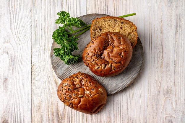 Pagnotte di pane e un ramo di prezzemolo su una tavola di legno rotonda