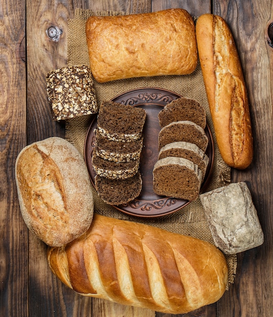 Pagnotte fresche di pane con grano e glutine su un tavolo di legno