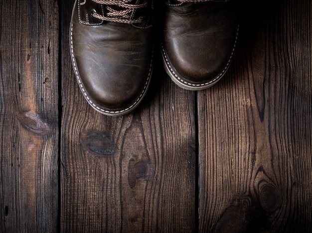 Paia delle scarpe marroni di cuoio su un fondo di legno