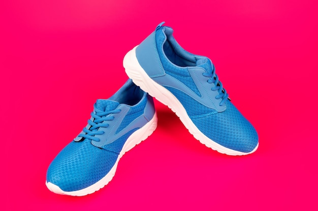 Paio di comode scarpe sportive blu su sfondo rosa nuovo paio