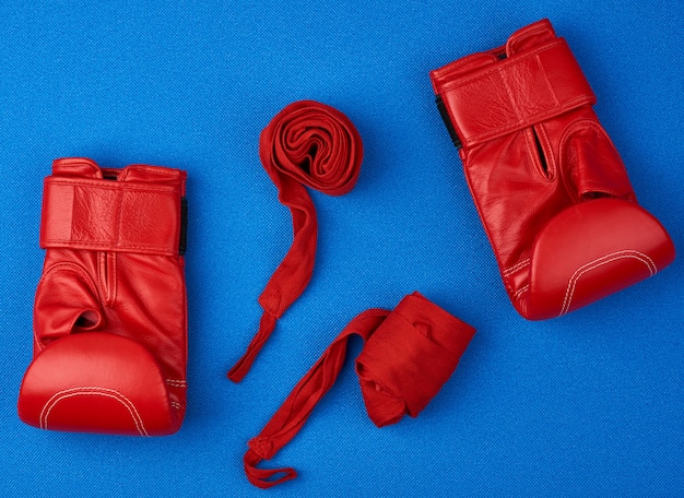 Paio di guantoni da boxe in pelle rossa, fascia elastica in tessuto rosso per le mani