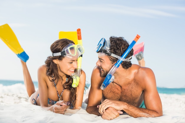 Paio di indossare pinne in spiaggia