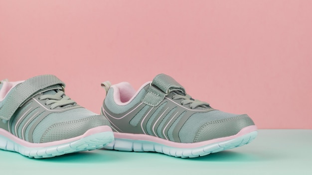 Paio di scarpe sportive alla moda su sfondo rosa e blu.