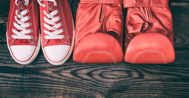 Paio di sneakers rosse e guanti da boxe in pelle rossa