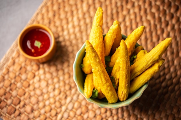 Pakoda pakora di mais fritto croccante o frittelle di mais servite con cibo indiano ketchup