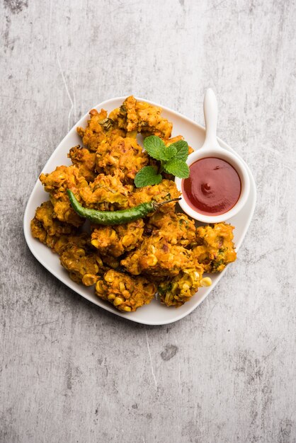 Pakora di mais croccante o pakoda, bhajji, Bhaji, bajji o pattice. servito con ketchup