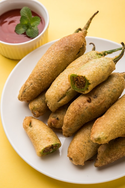 Pakora di peperoncino verde croccante o Mirchi Bajji, servito con ketchup di pomodoro. È un popolare spuntino per l'ora del tè dall'India, specialmente nei monsoni. Messa a fuoco selettiva