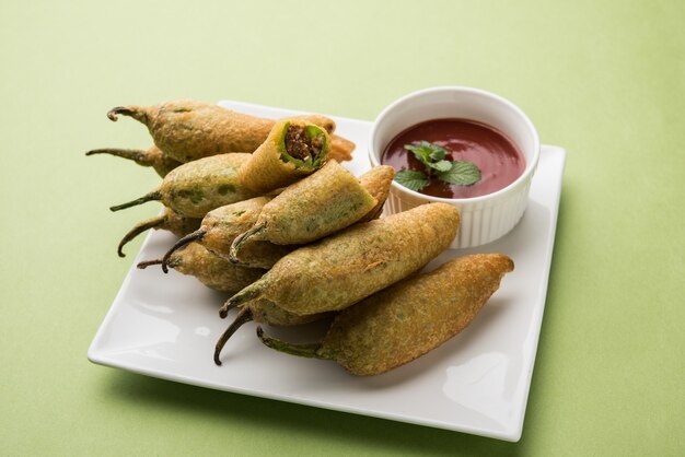 Pakora di peperoncino verde croccante o Mirchi Bajji, servito con ketchup di pomodoro. È un popolare spuntino per l'ora del tè dall'India, specialmente nei monsoni. Messa a fuoco selettiva