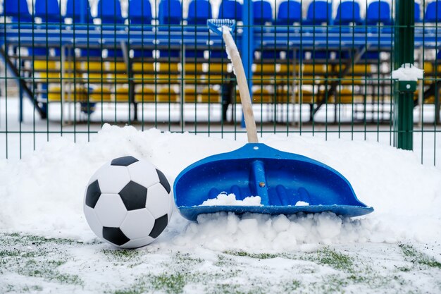 Pala, campo da calcio innevato e pallone da calcio classico