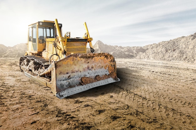 Pala gommata cingolata o bulldozer in un cantiere edile in una cava Potenti attrezzature moderne per lavori di sterro Cantiere Noleggio di attrezzature edili