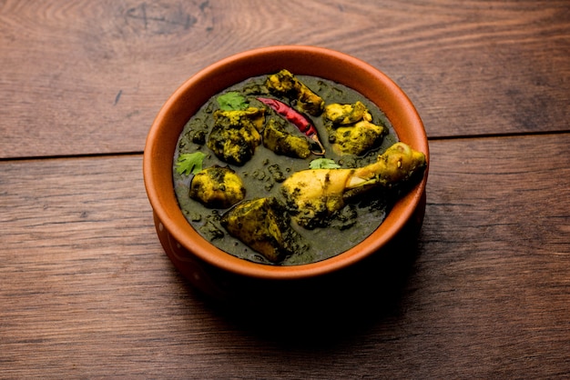 Palak o spinaci Pollo o Murg Saagwala servito in una ciotola con Naan e riso