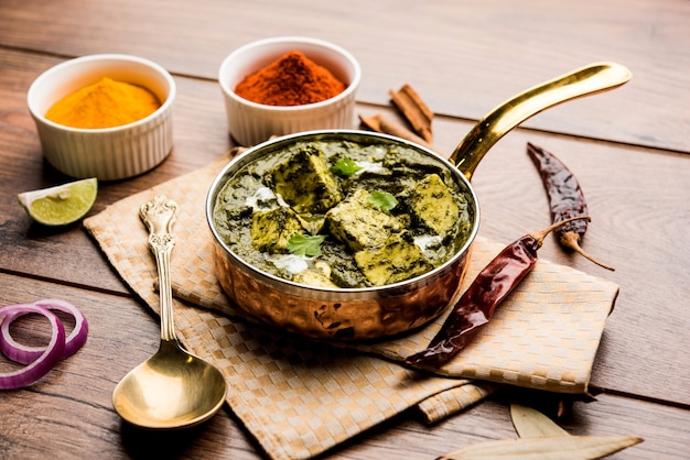 Palak Paneer Curry a base di spinaci e ricotta servito in una ciotola o padella con roti o riso