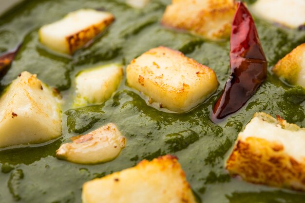 Palak Paneer Curry composto da spinaci e ricotta, menu di cibo salutare per pranzo o cena indiano popolare, servito in un Karahi con Roti o Chapati su sfondo lunatico. messa a fuoco selettiva