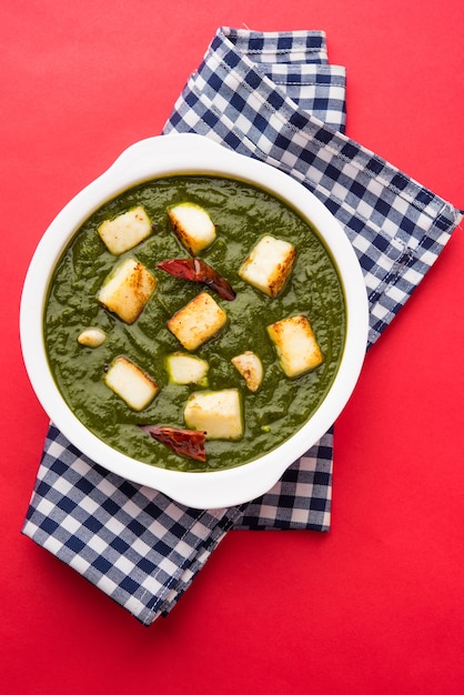 Palak Paneer Curry composto da spinaci e ricotta, menu di cibo salutare per pranzo o cena indiano popolare, servito in un Karahi con Roti o Chapati su sfondo lunatico. messa a fuoco selettiva