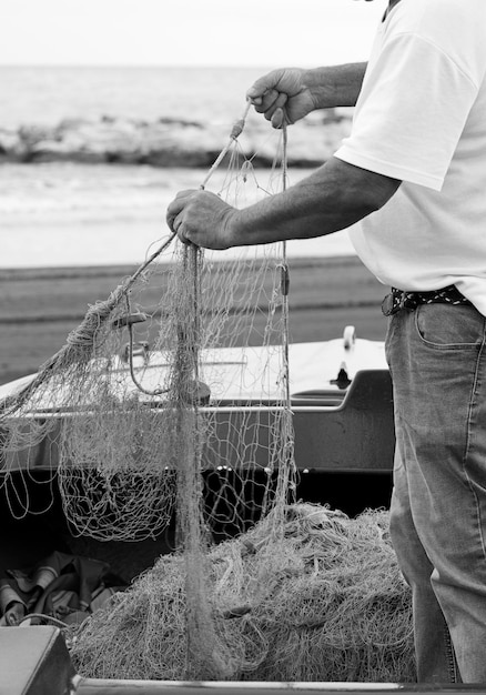 Palangre di pesca, reti di cattura del pesce, il pescatore corregge e prepara il materiale per lavorare