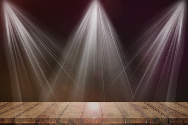Palcoscenico luminoso sullo sfondo del tavolo in legno della stanza buia
