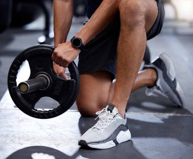 Palestra fitness o allenamento delle mani con un bilanciere o attrezzature pesanti per la crescita muscolare o l'allenamento di sviluppo Scarpe bodybuilder o uomo sano e forte che inizia l'esercizio di allenamento della forza di sollevamento pesi