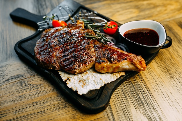 Paletta con pomodori, cipolla e salsa sul piatto di legno.