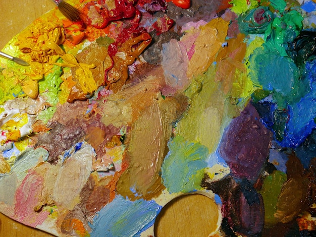 Palette artistica colorata piena di vernici acriliche