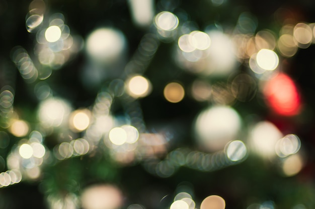 Palla astratta della decorazione della sfuocatura di colore e corda leggera sull'albero di Natale con bokeh