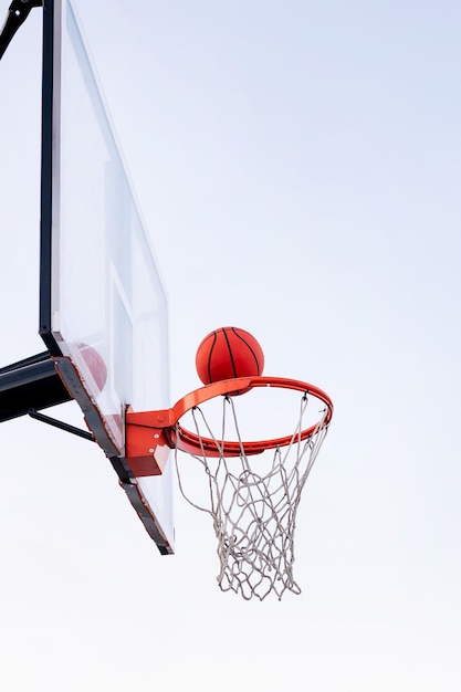 Palla che entra in un canestro da basket con il cielo sullo sfondo il concetto di sport urbano all'aperto copia spazio per il testo