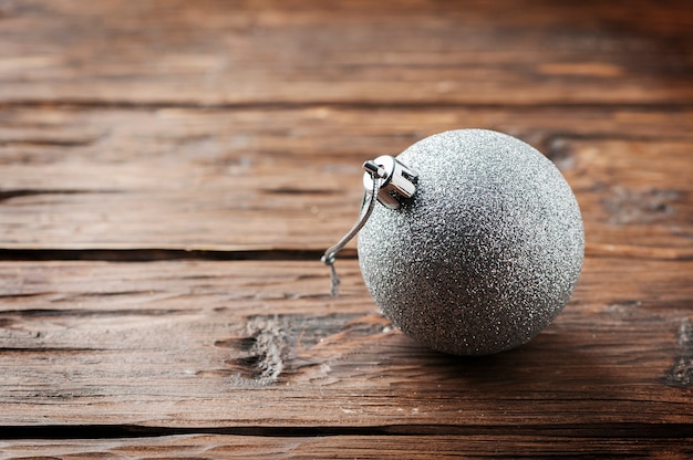 Palla d'argento per natale sulla tavola di legno