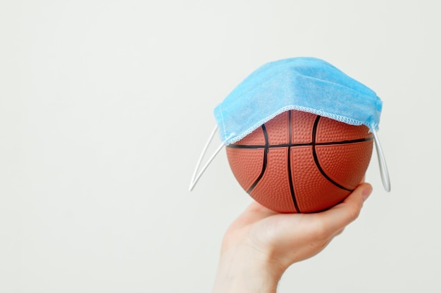 Palla da basket con mascherina medica.