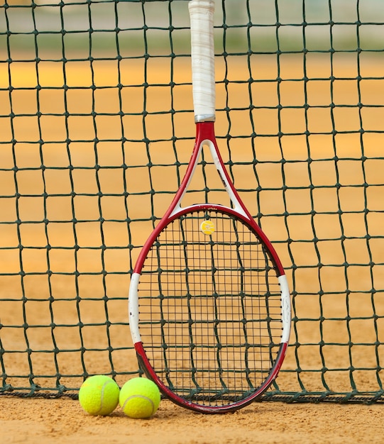 Palla da tennis e racchetta sul campo in terra battuta