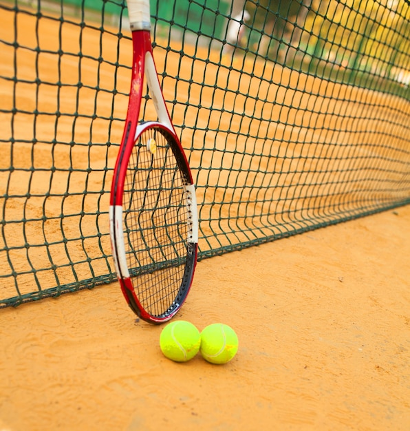 Palla da tennis e racchetta sul campo in terra battuta