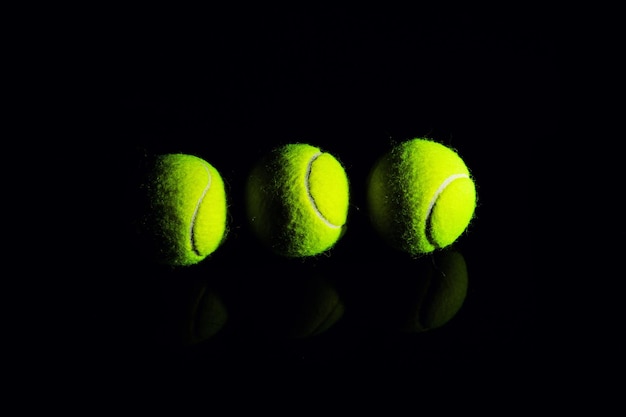 Palla da tennis isolata sul nero con illuminazione drammatica