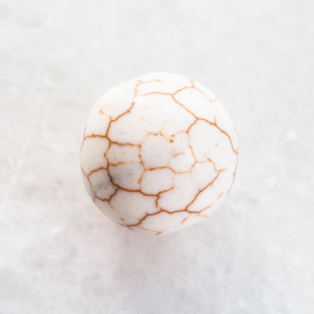 Palla dalla pietra preziosa incrinata di Cacholong su bianco