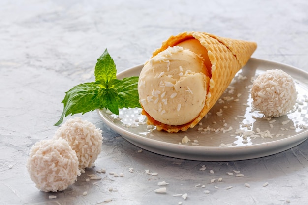 Palla di gelato al cocco in un cono di cialda