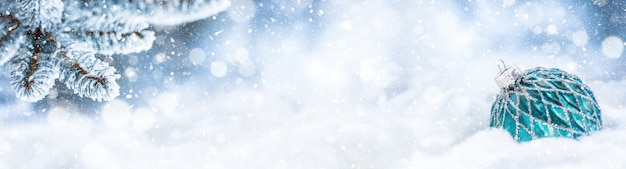 Palla di Natale blu sulla neve con rami di abete. Buon Natale concetto - banner panoramico.