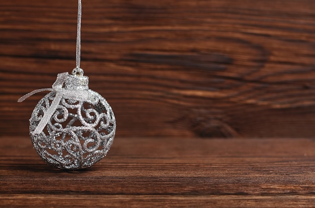 Palla di Natale d'argento su uno sfondo di legno