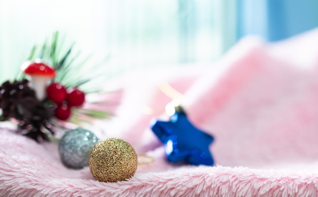 Palla di Natale d'oro e d'argento sul maglione rosa con overlight dalla finestra Sfondo per buon Natale e felice anno nuovo 2023 ConceptSpazio libero per la presentazioneDecorazione natalizia