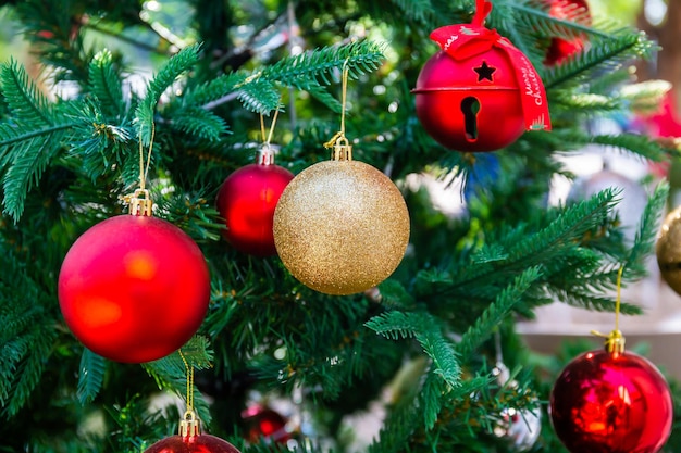 Palla di Natale rossa e dorata con campane sull'albero per festeggiare Natale e Capodanno