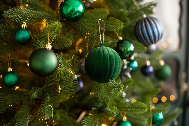 Palla di Natale verde su un albero di Natale sullo sfondo della casa