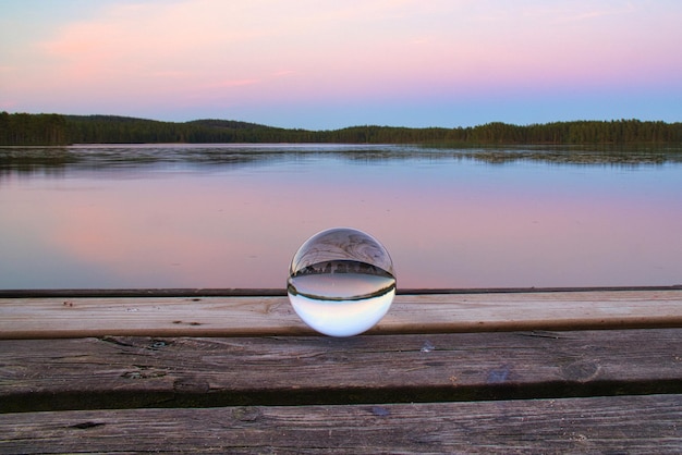 Palla di vetro su un molo di legno in un lago svedese all'ora serale Natura Scandinavia