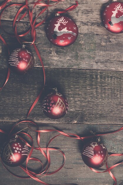 Palla e nastri rossi di Natale su fondo di legno. Carta di Capodanno.