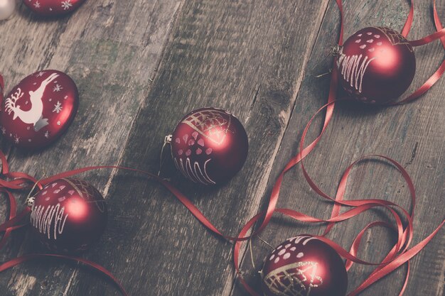 Palla e nastri rossi di Natale su fondo di legno. Carta di Capodanno.