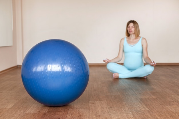 Palla fitness blu sullo sfondo di una donna incinta. più blu
