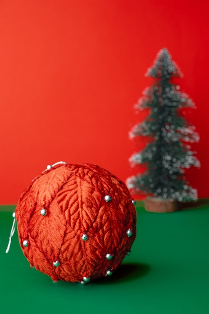 Palla rossa d'annata dei christams e decorazione dell'ornamento dell'albero di natale sulla tavola verde con rosso vivo