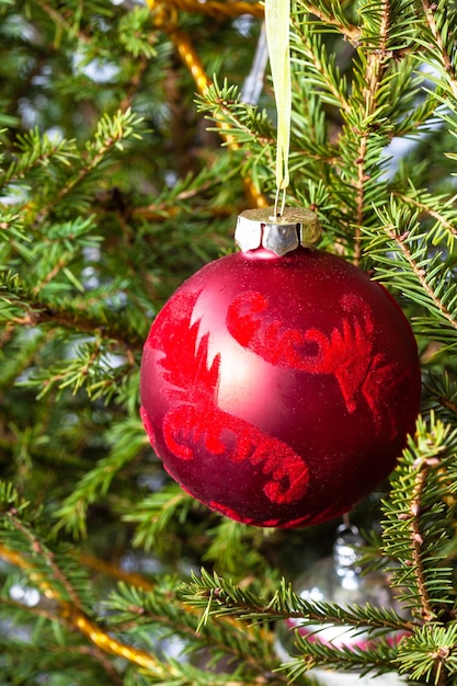 Palla rossa decorata sull'albero di Natale naturale