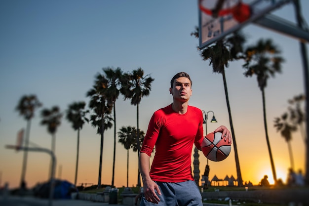 Pallacanestro di formazione del giocatore di basket su un campo a Venice Beach.