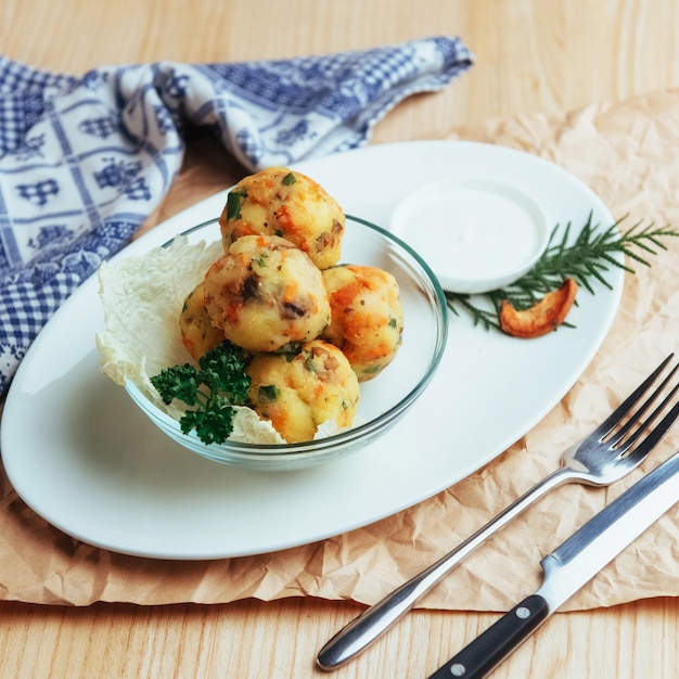 Palle di falafel di ceci con tavolo in legno di verdure.