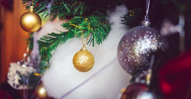 Palle di Natale d'oro e palle rosse con nastri rossi adornano l'albero di Natale Sfondo Natale