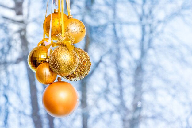 Palle di Natale dorate sullo sfondo degli alberi fuori dalla finestra in inverno_