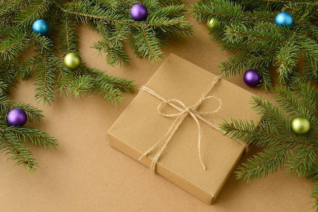 Palle di Natale su rami di abete verde confezione regalo su carta kraft. Sfondo di Natale o Capodanno