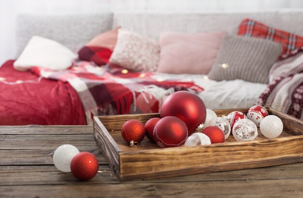 Palle di Natale sulla vecchia tavola di legno sul divano con cuscini e plaid