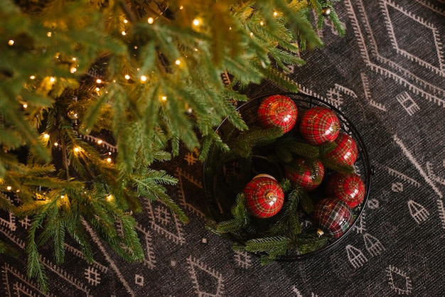 Palle giocattolo rosse giacciono sotto l'albero di Natale in una scatola Vista dall'alto